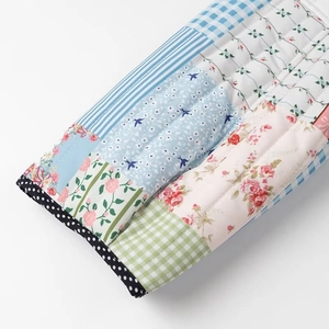 Close-up of quilted floral patchwork sleeves with polka dot trim on long sleeve jacket
