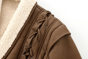 Details des Lammfellfutters und der Schnürung mit Metallösen an brauner Wildlederjacke
