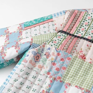 Detailed view of quilted patchwork jacket featuring floral patterns and polka dot trim