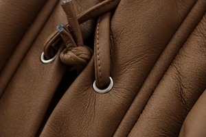 Detail der braunen Wildlederjacke mit Metallösen und Leder-Kordelzug für Damenmode