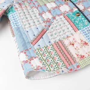 Close-up of quilted floral patchwork jacket with wooden buttons and polka dot trim
