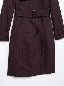 Detail view of double-breasted trench coat with waist belt and deep purple twill fabric