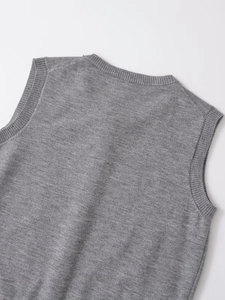 Detail of grey knitted vest showing ribbed crew neck and high-quality fabric texture