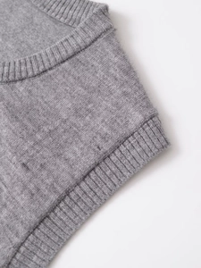 Close-up of premium grey knit vest featuring textured rib-knit neckline and soft wool fabric