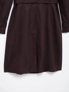 Detail of slim-fit trench coat showing high-density woven fabric and waist belt buckle