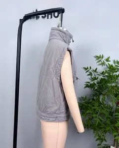 Detail view of grey quilted puffer vest featuring wavy stitching and stand collar