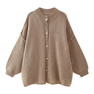 Detailed close-up of textured taupe knit sweater with premium gold metal buttons