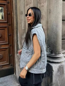 Detail of grey quilted gilet featuring diamond pattern and adjustable drawstring hem