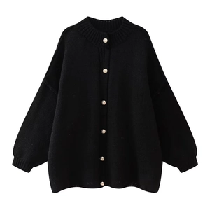 Close-up of black oversized knit cardigan featuring decorative gold embossed metal buttons