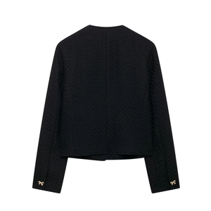 Détail du dos d'une veste en tweed avec tissage texturé et boutons dorés aux poignets