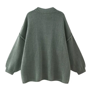 Detail of greyish green knitted sweater featuring ribbed cuffs and thick textured wool blend