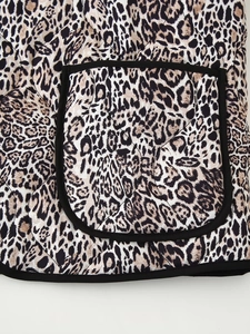 Detail of leopard print quilted jacket featuring a patch pocket and black trim finish