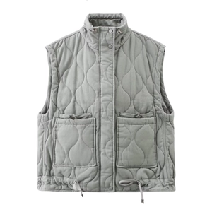 Detail of grey quilted vest featuring high collar with snaps and adjustable drawstring hem