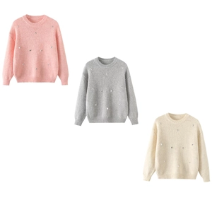 Detail view of pink, grey, and white knit sweaters with small rhinestone embellishments