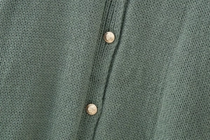 Close-up of sage green knit cardigan featuring vintage gold embossed metal buttons
