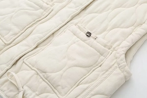 Detail of quilted vest showing drawstring adjusters and large functional flap pockets