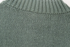 Macro detail of rib-knit crewneck and fine texture on sage green cardigan sweater