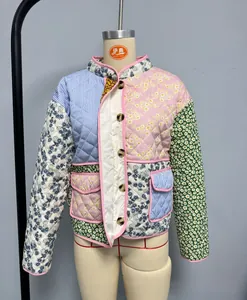 Detail view of multicolored patchwork quilted jacket with floral prints and button closure