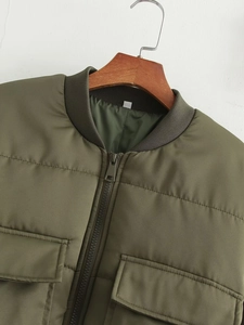 Detail einer olivgrünen gesteppten Bomberjacke mit Metallreißverschluss und Taschen
