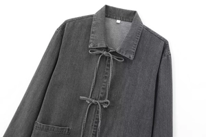 Détail d'une chemise en jean gris foncé avec des nœuds à nouer et une poche poitrine