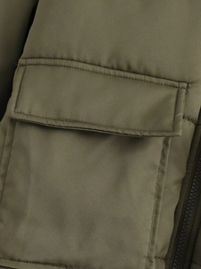 Detail der armee-grünen Steppjacke mit funktionalen Klappentaschen und robustem Reißverschluss