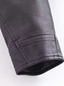 Détail de la double couture et texture du similicuir sur le poignet de la veste noire