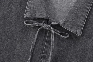 Détail du col à revers avec nœud sur une chemise en jean noir délavé