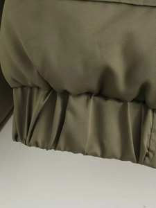 Nahaufnahme der olivgrünen Jacke mit elastischem Saum und hochwertiger Stoffstruktur