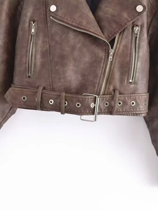 Détails d'un blouson motard marron foncé en similicuir avec fermetures éclair et ceinture