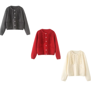 Detail of knit cardigans with wave trim, white buttons, and pockets in three colors