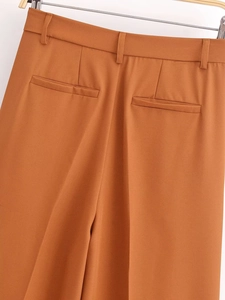 Detail view of high waisted brown wide leg trousers showing waistband and back pockets