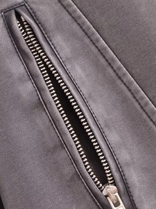 Détail de la veste en similicuir gris foncé avec fermeture éclair en métal et texture