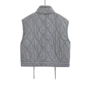 Macro detail of grey quilted vest featuring onion pattern stitching and drawstring hem