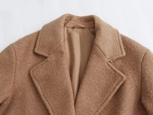 Detail shot of camel wool blend coat featuring classic lapels and premium smooth lining