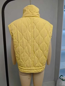 Detailed back view of yellow quilted vest with wave diamond stitching and stand collar