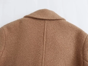 Close-up of camel wool texture on a women's coat showing the lapel and stitching details