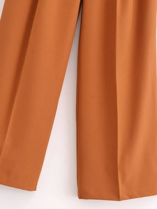 Detail view of caramel pleated wide leg trousers with premium vertical texture drape