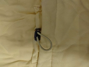 Detailed close-up of quilted vest with adjustable drawstring and black toggle button