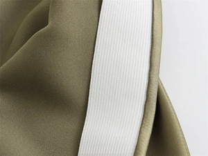 Detail of olive green satin skirt showing waist stitching and white elastic band