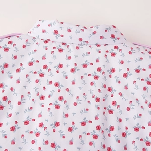 Close-up of elegant floral stand collar coat with red roses and lace-up details