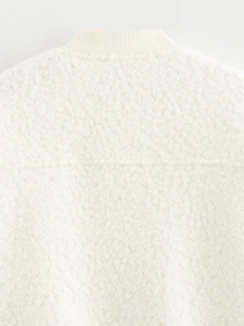 Close-up of cream fleece jacket showing textured fabric and ribbed knit collar detail