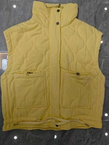 Detail showing quilted texture and front snap buttons on this yellow padded vest