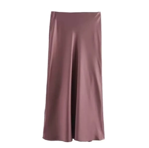 Close-up of silky satin fabric texture and high waist seam on this pink midi skirt