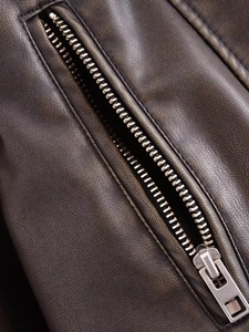 Détail de la fermeture éclair métallique et du similicuir texturé sur veste motard