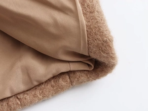 Detail view of brown faux fur texture and smooth inner lining on stylish coat