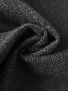 Detailed close-up of dark grey knitted fabric showing soft wave texture and fine stitching