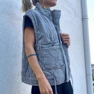 Women's blue quilted vest featuring high collar and wave-pattern stitching details