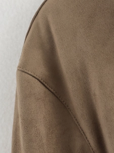 Detailaufnahme der Schulter einer braunen Wildlederjacke mit feinen Nähten und Textur