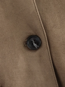 Detailaufnahme der braunen Veloursjacke mit matter Textur und schwarzem Vierloch-Knopf