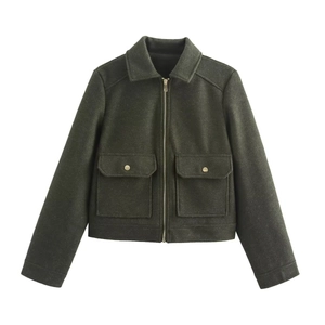 Detail of forest green tweed jacket showing golden zipper and front flap pockets